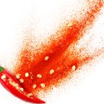 Chili powder bursting out of a cut open chili pepper